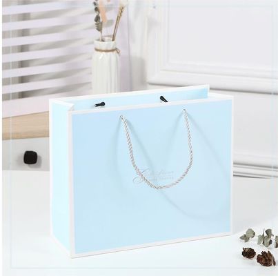 Bolso de compras impreso a medida de cartón Bolso de regalo de papel kraft blanco de lujo con mango de cinta